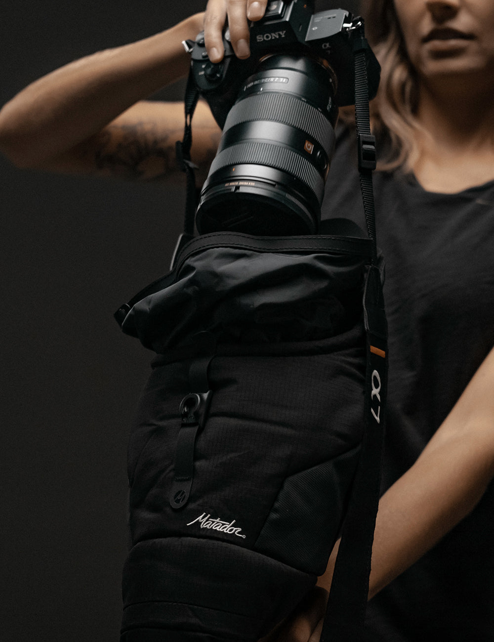 woman pulling camera out of base layer