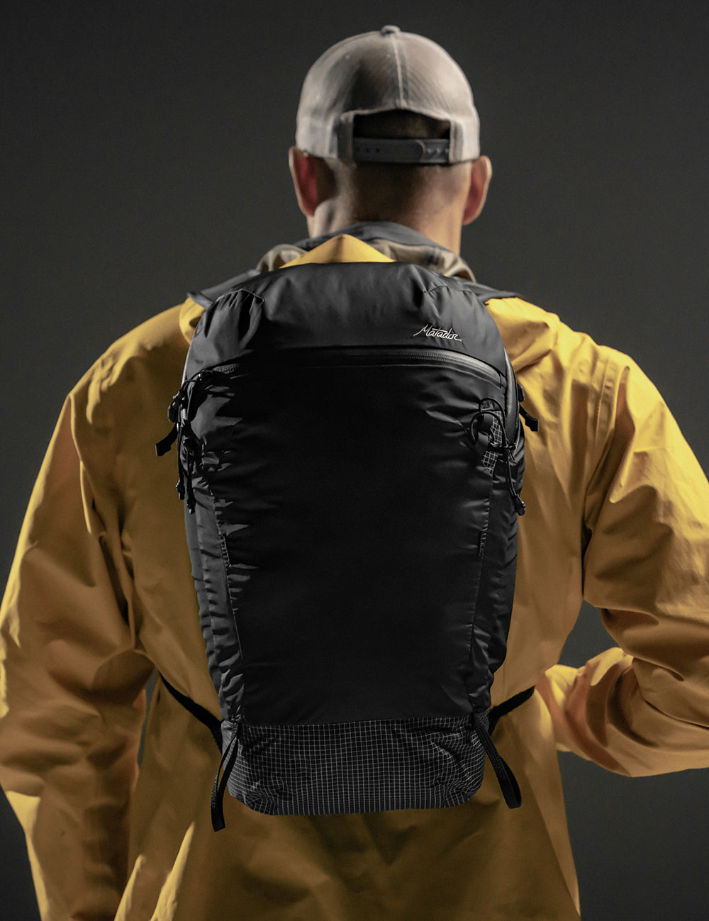 man in yellow jacket wearing black backpack