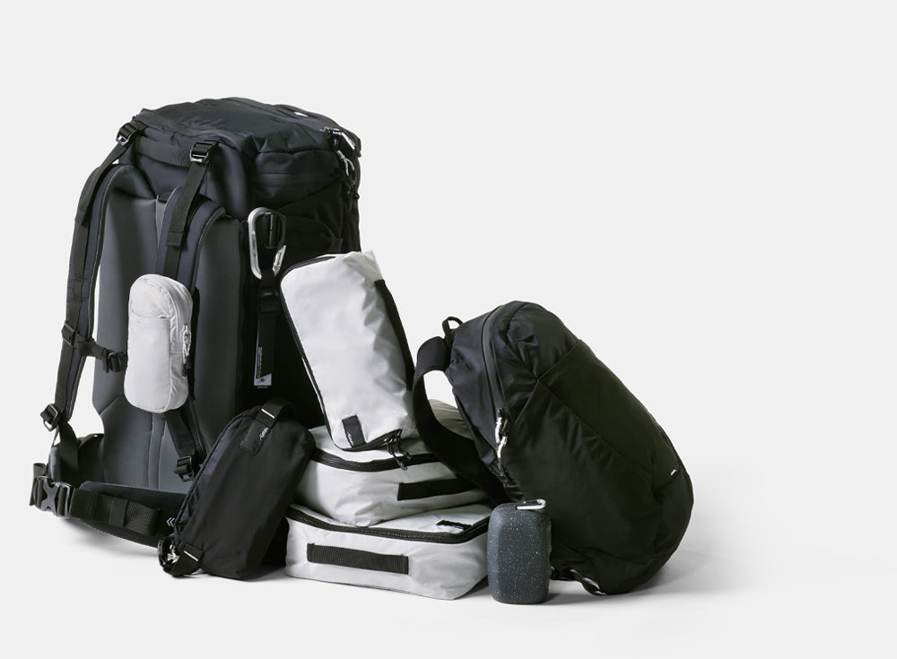 Pile of black and white matador bags and accessories on light gray backgound