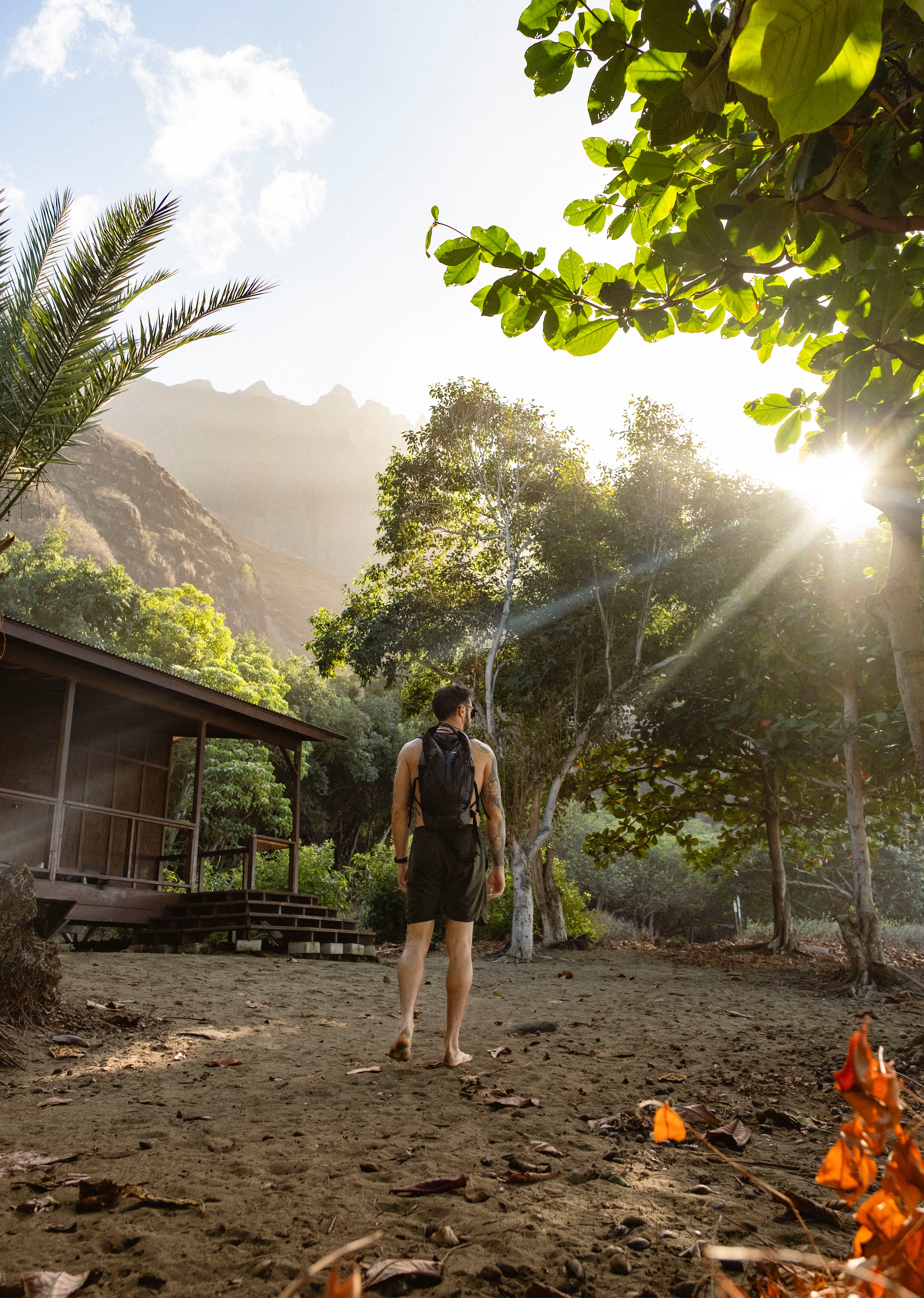 man wearing frerain22 backpack next to hawaiian home