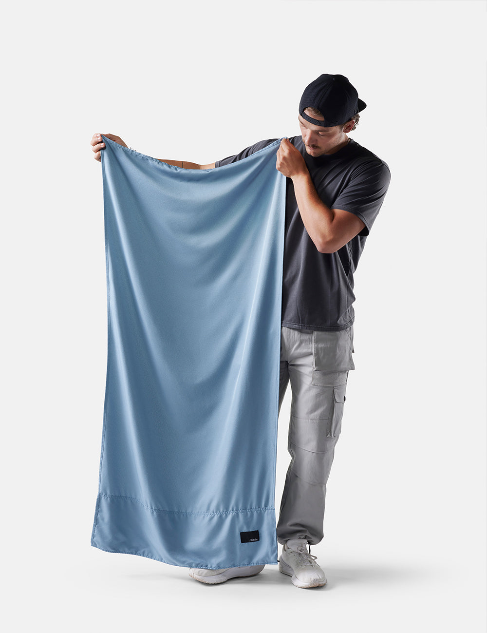 Man holding a slate towel against a white background