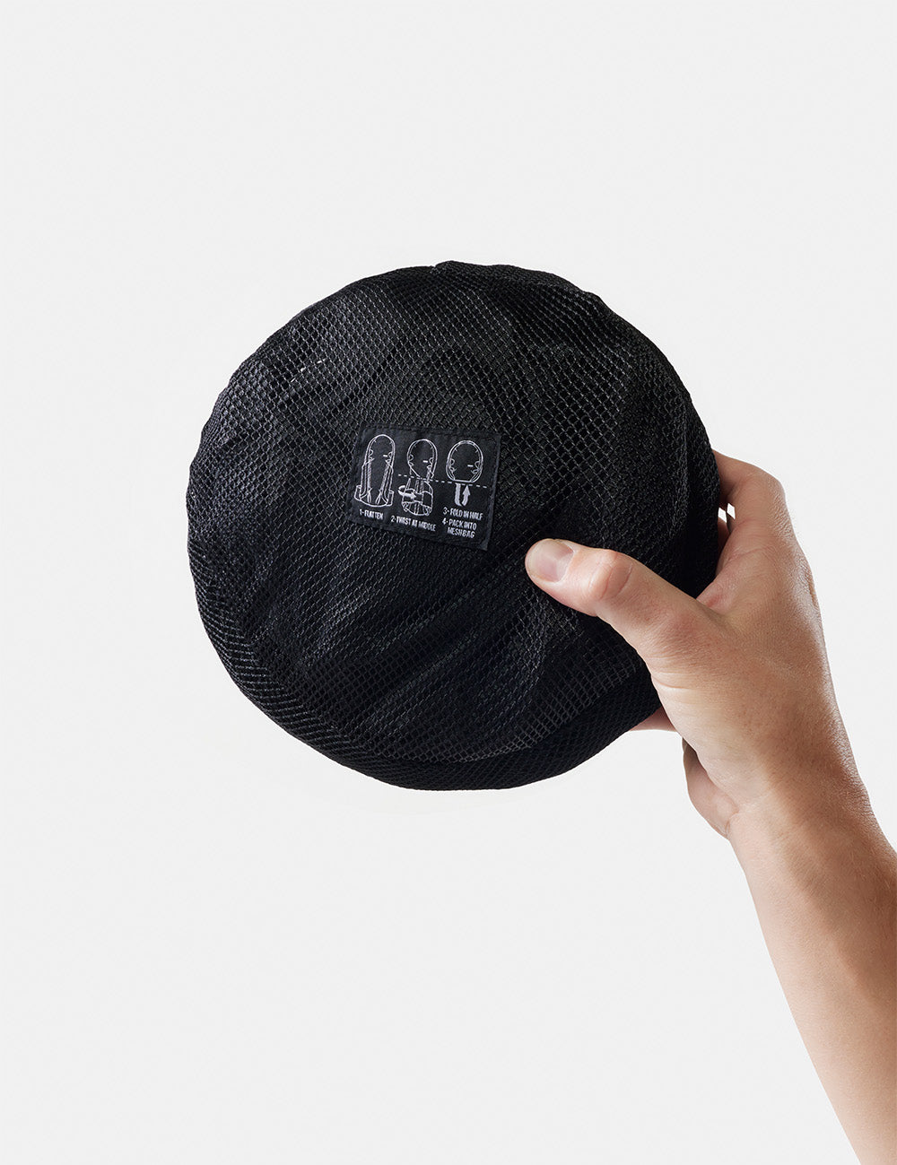 hand holding packed up backpack on white backgroune