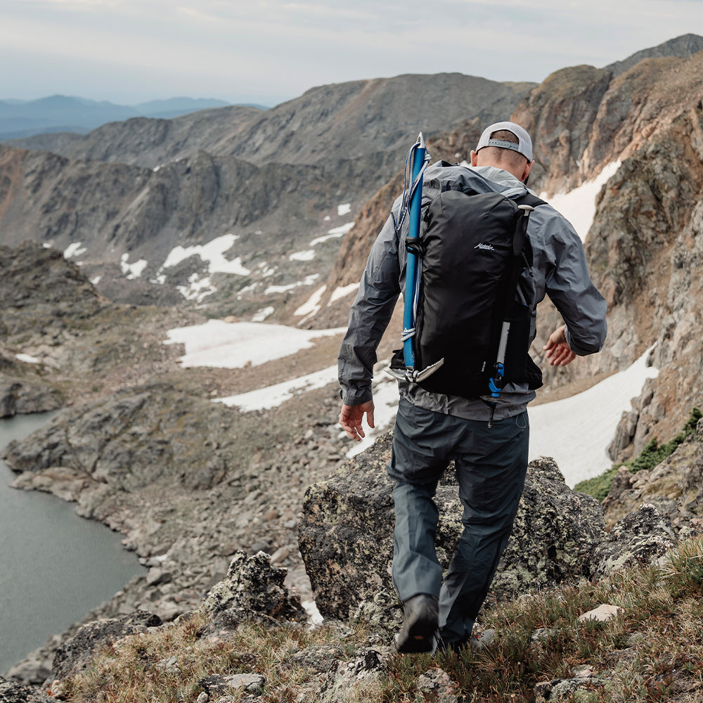 man on rocky terrain wearing black backpack