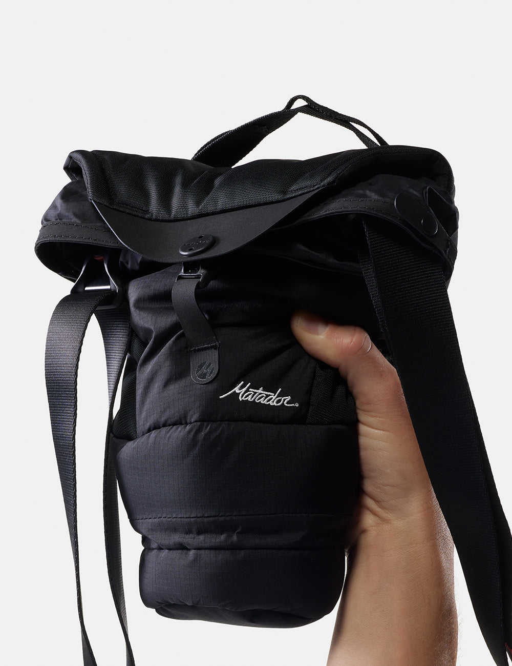 hand holding camera base layer with strap on white background