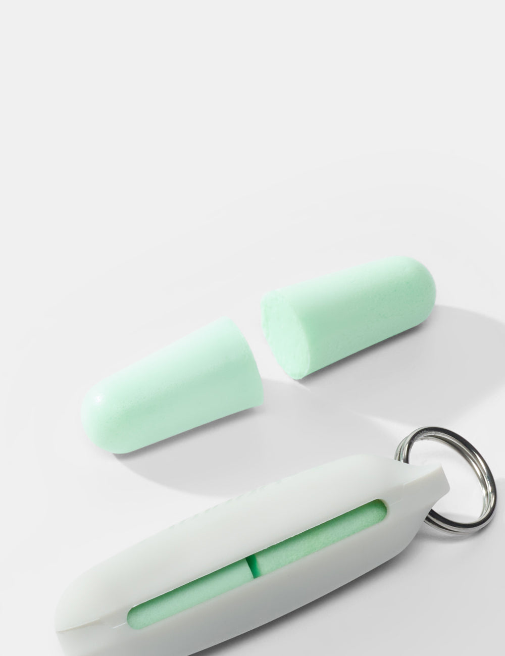 close up view of mint colored earplugs on white background