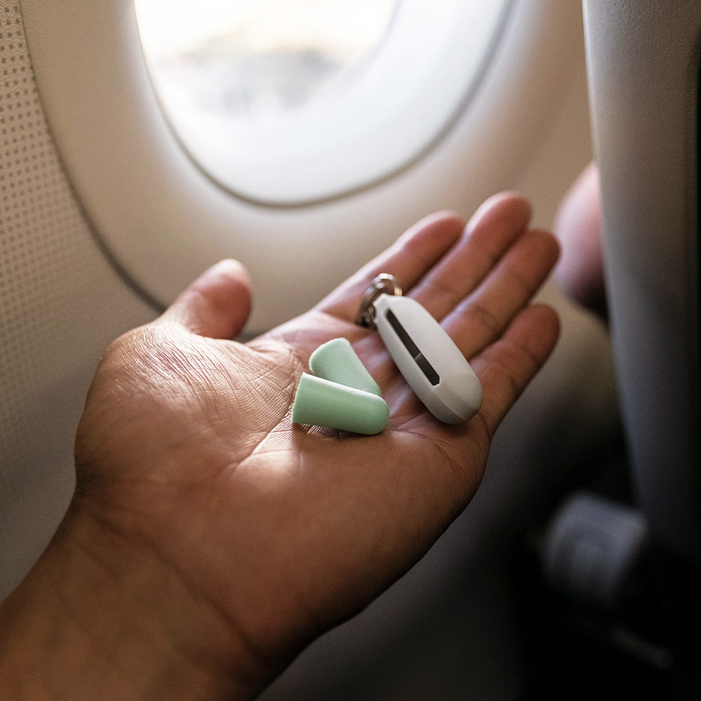 hand holding earplug kit on airplane