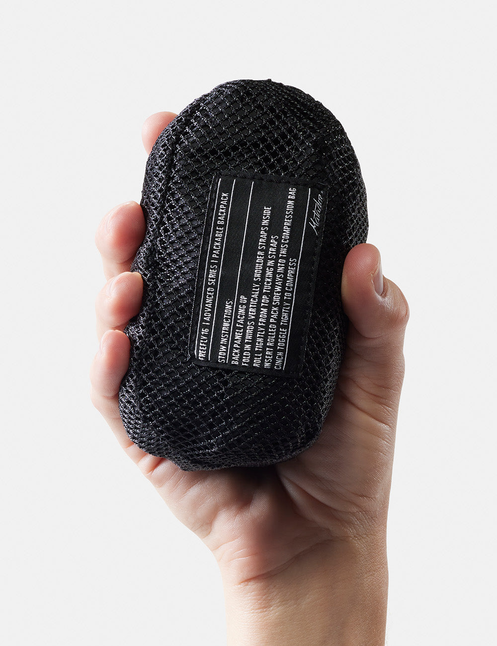 hand holding packed up backpack