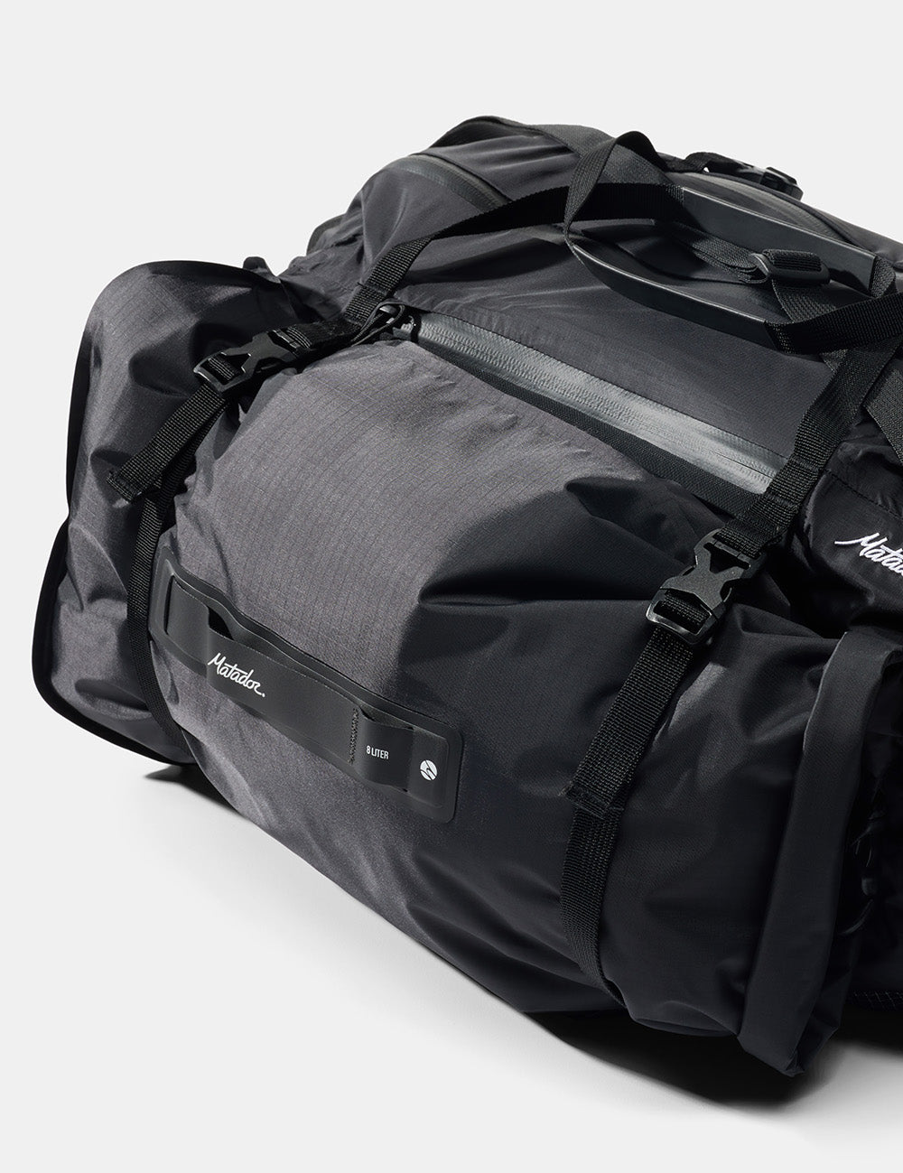 black duffle with black dry bag attached by gear loops