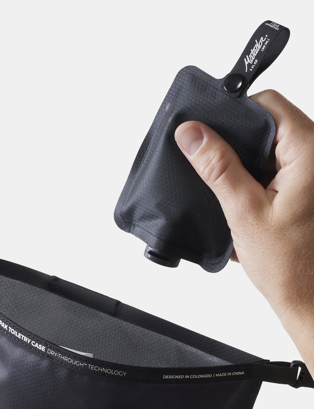 hand putting toiletry bottle into toiletry case