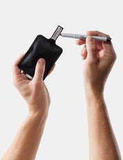 Person using a black Sharpie marker holder with a white Sharpie pen on a light gray background