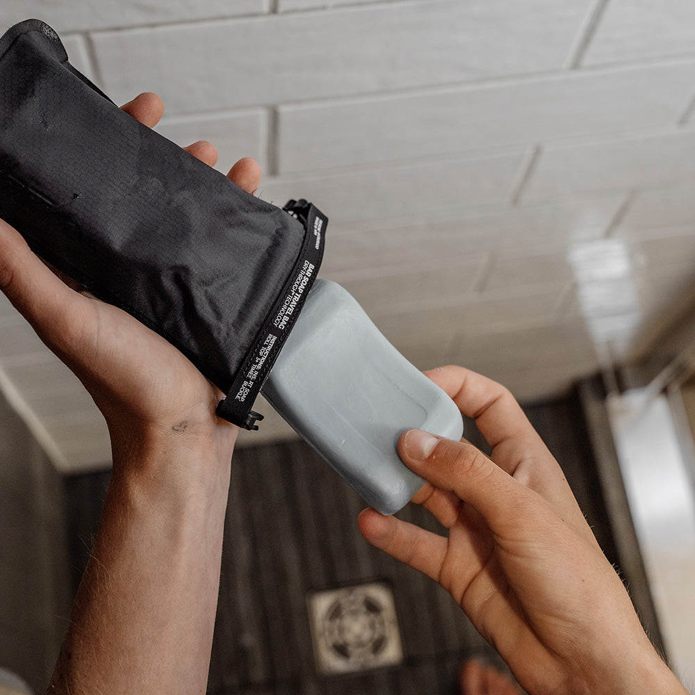 pulling gray soap out of soap bar case in shower