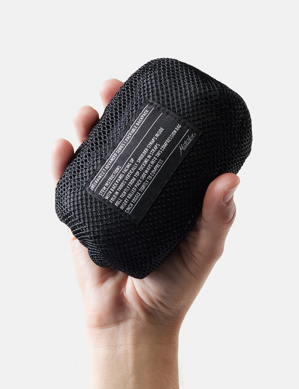 hand holding packed up backpack