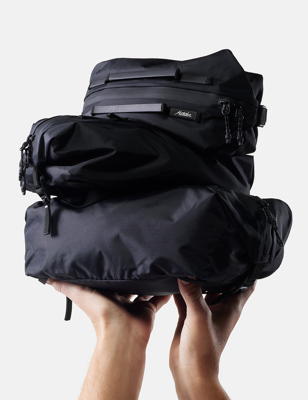 hands holding up a pile of 3 gear cubes on white background