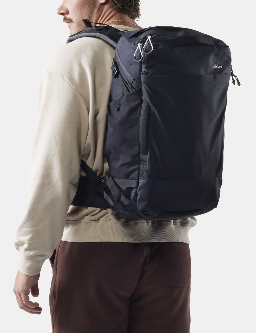 man wearing black backpack on white background