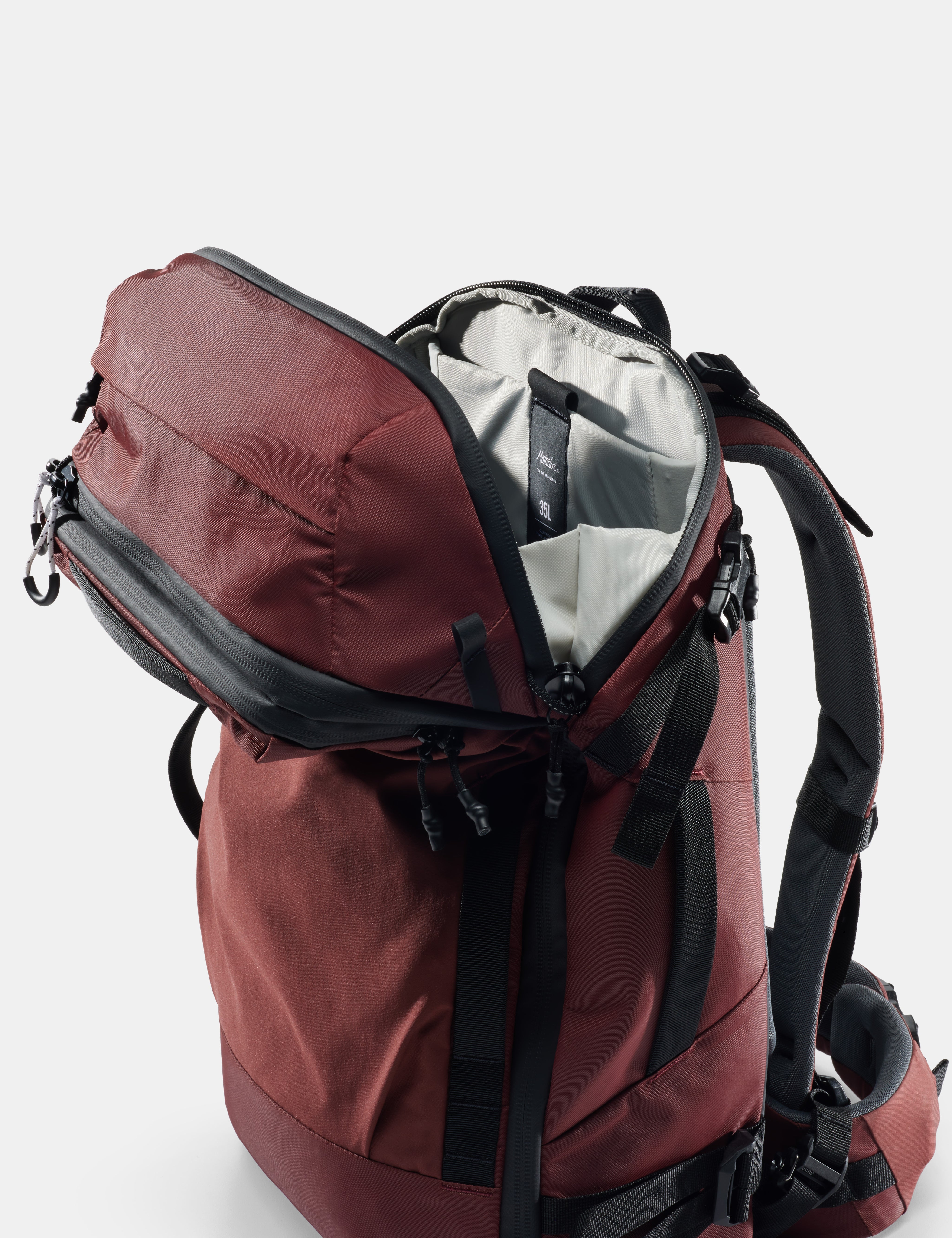 Red backpack with open compartment on a white background