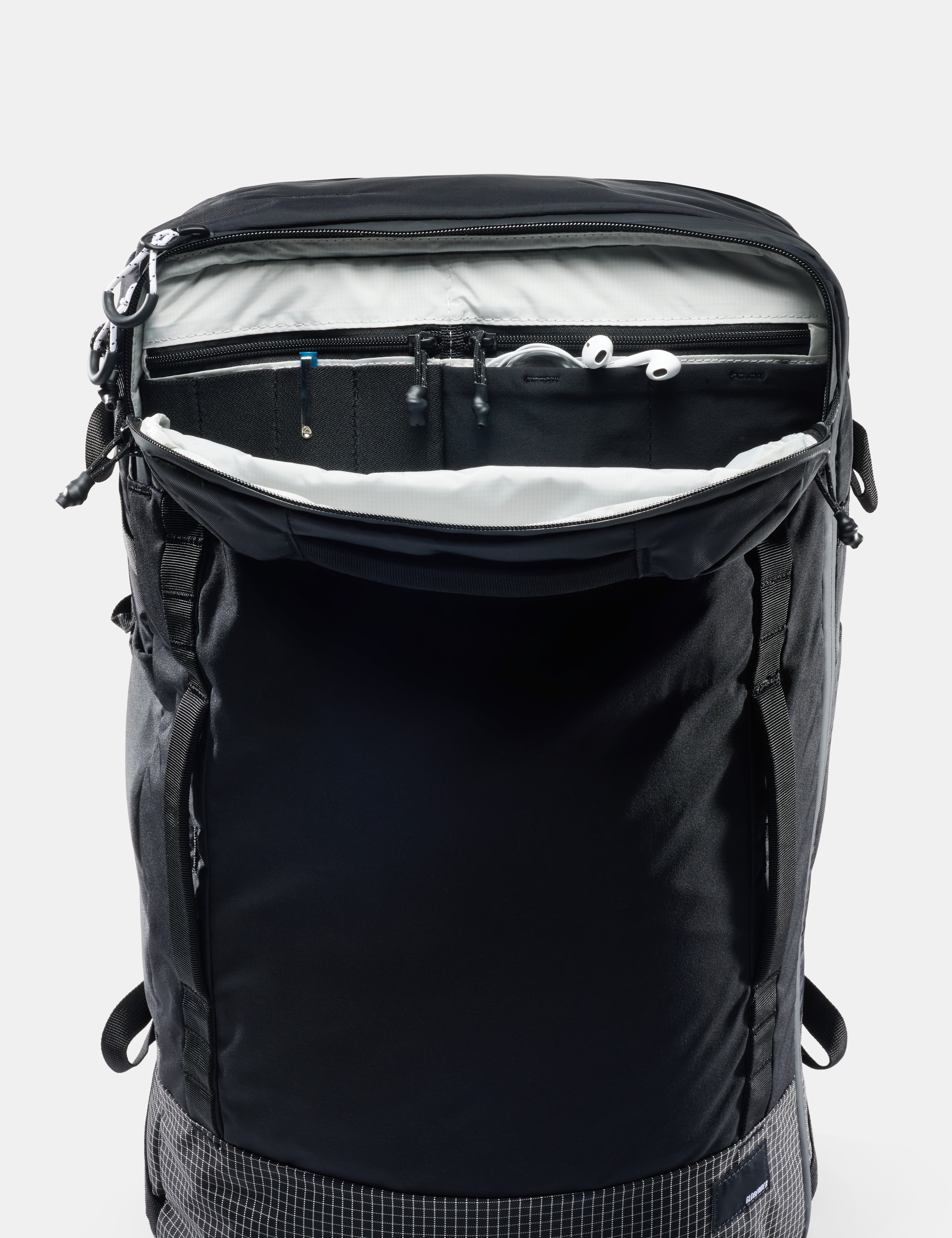 Black backpack with open front compartment on a white background