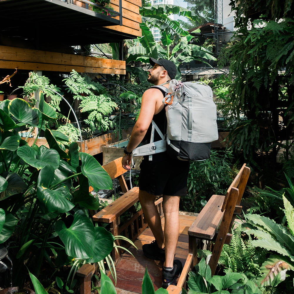 man in lush hotel wearing white backpack 