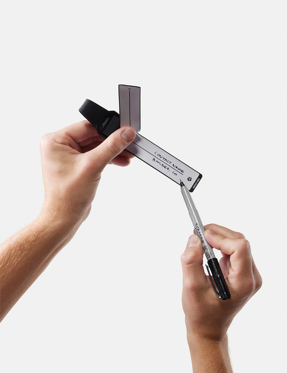 holding a pen to gear tag on white background