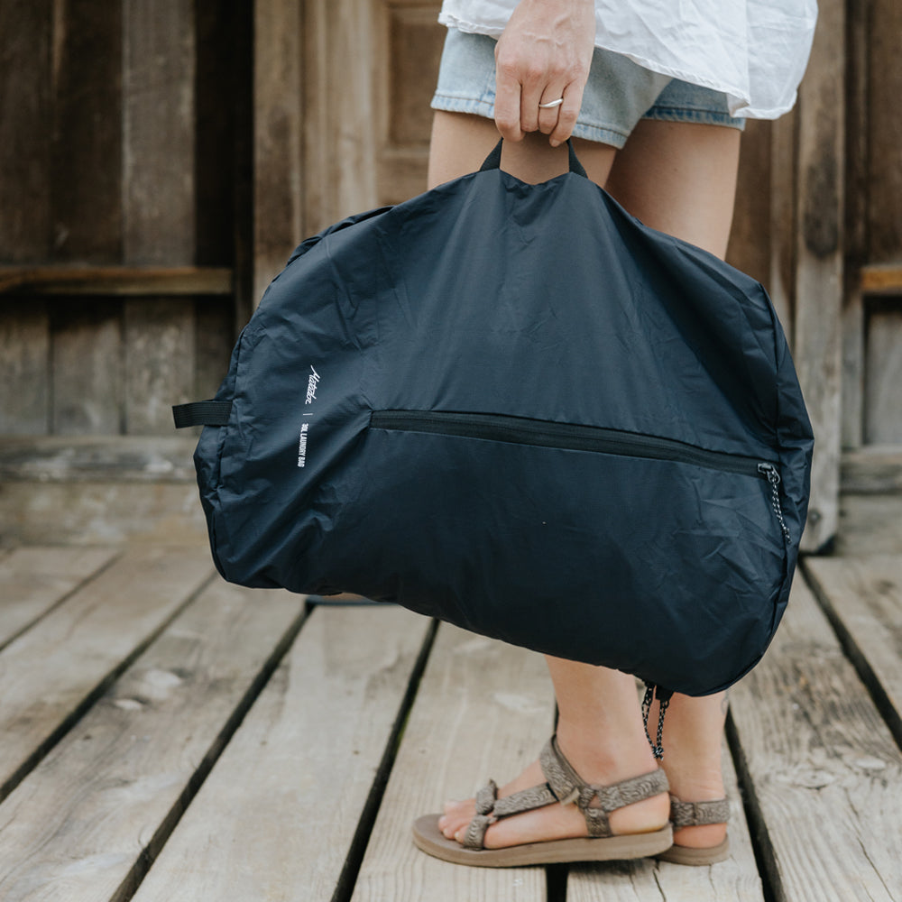 woman walking on Belize dock, carrying laundry bag