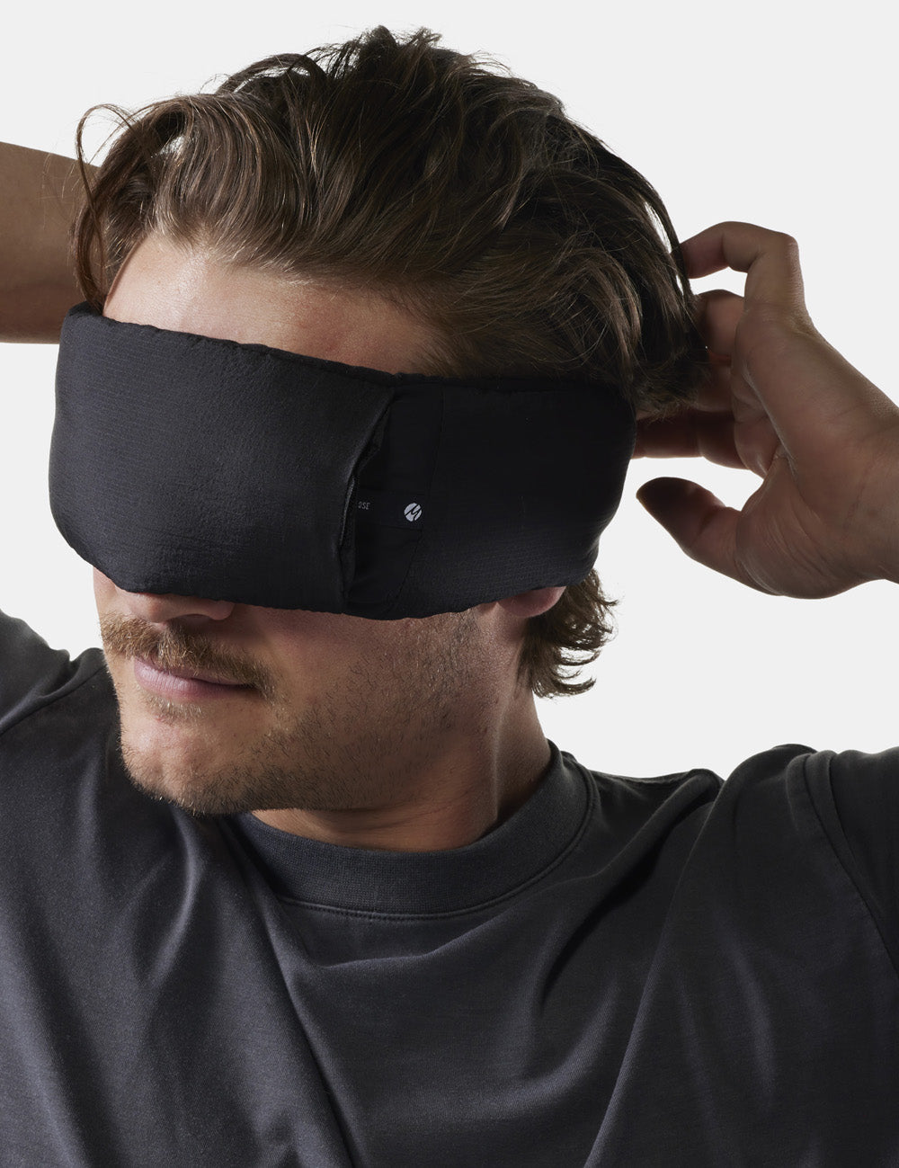 man adjusting sleep mask on his face