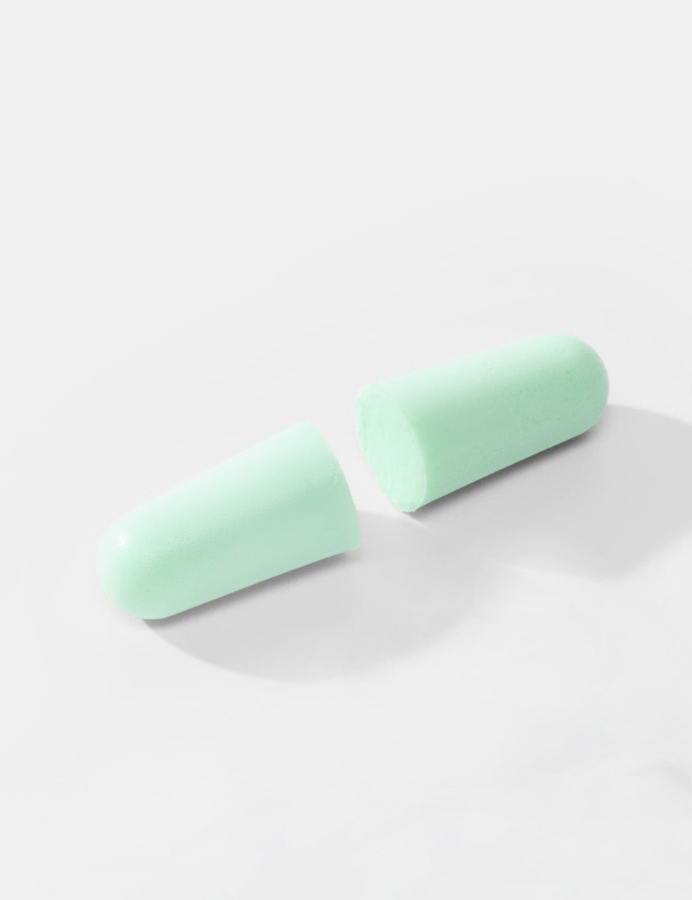 close up shot of mint colored earplugs on white background