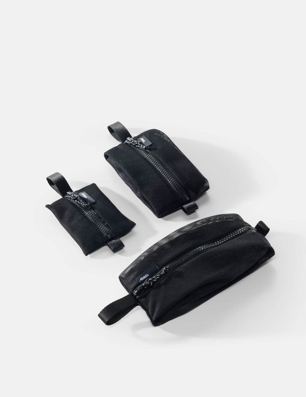 Three black pouches of varying sizes on a white background