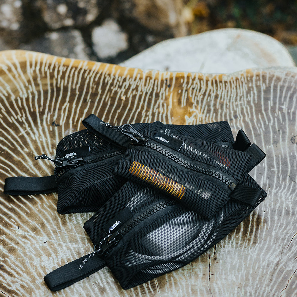 3 mesh bags full of items sitting on wood table