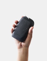 Hand holding nanodry towel case against a light gray background