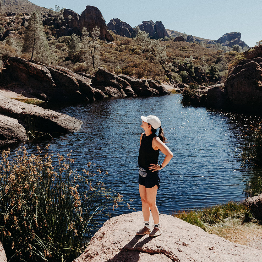 woman in front of natural lake, wearing hip pack