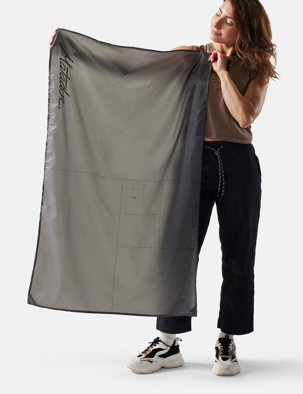 woman on white background holding up pocket blanket mini