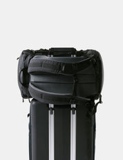 Black backpack with a white stripe on a light gray background