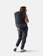 Person wearing a large black backpack on a white background