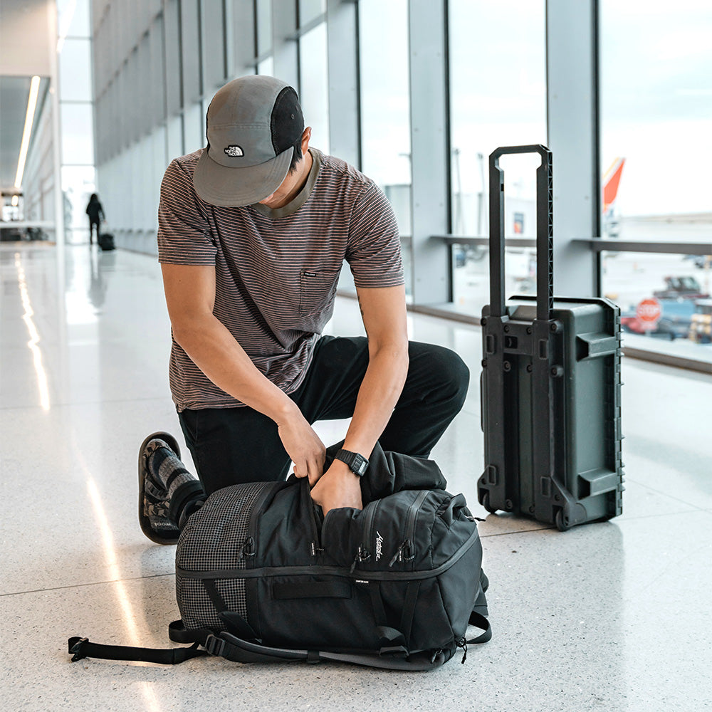 man in airport, rummaging through his black seg28