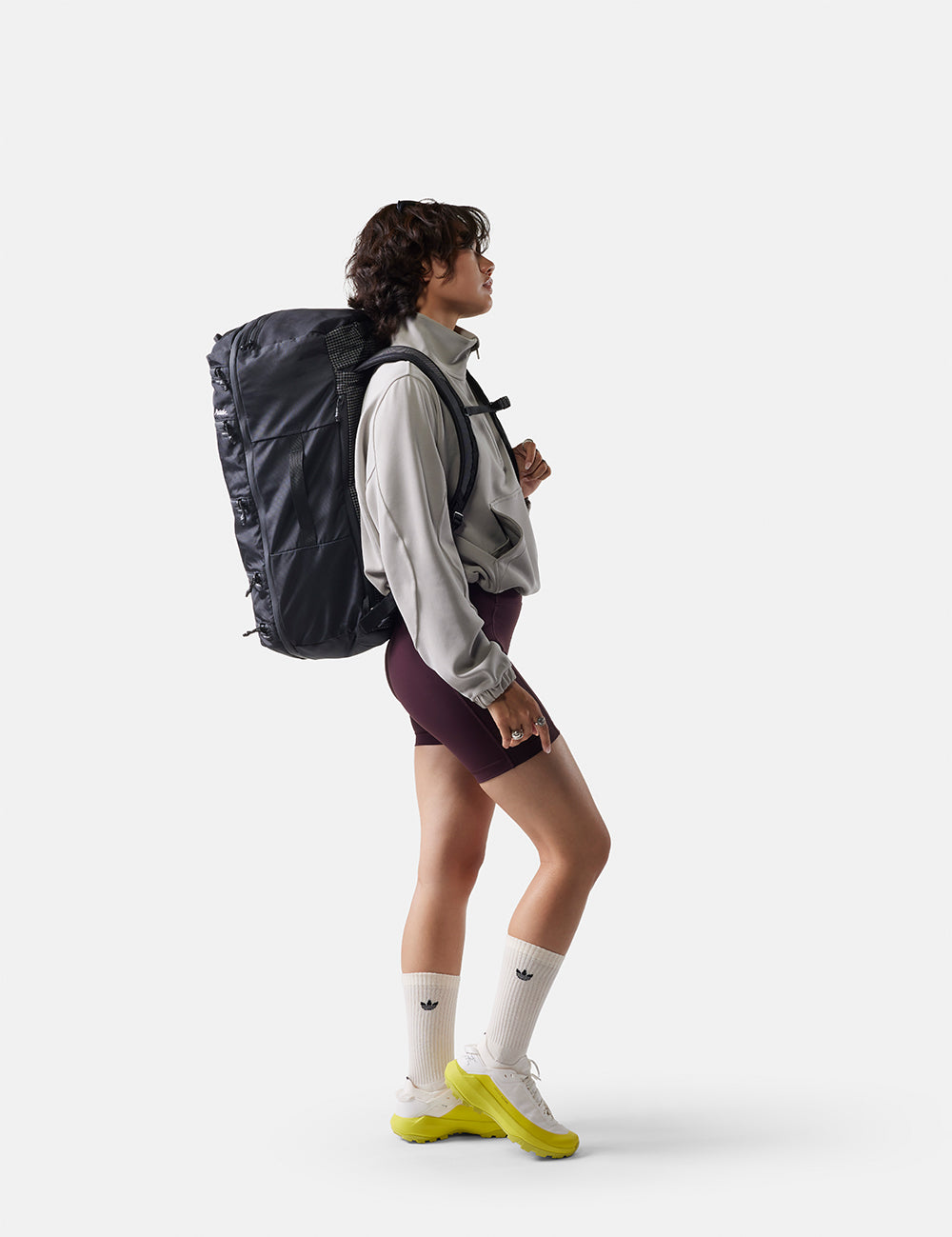 Person wearing a large backpack on a white background
