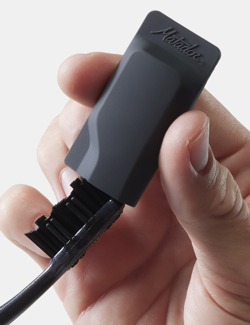 hand placing toothbrush cap onto black toothbrush