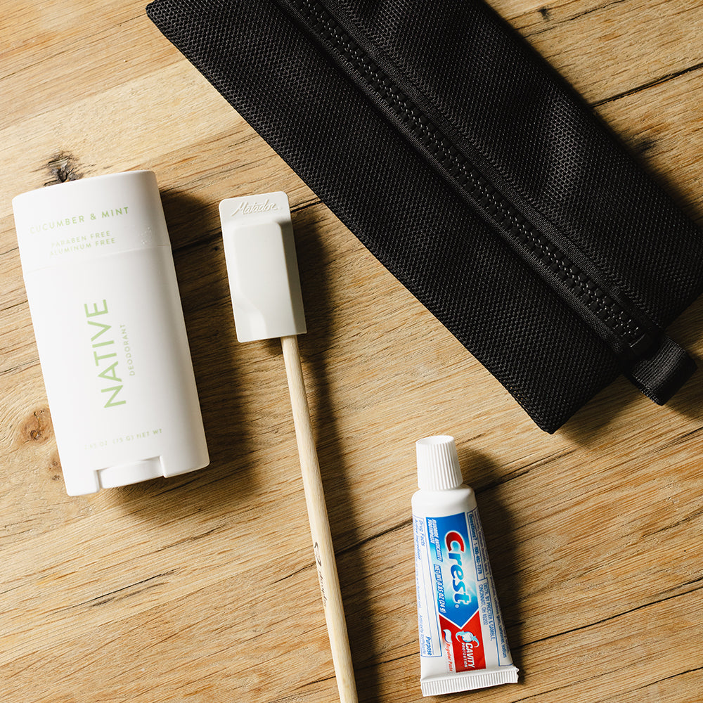 deodorant toothbrush and toothpaste on wood table