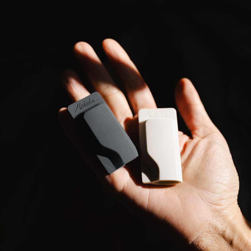 hand in dark moody shadows holding toothbrush caps