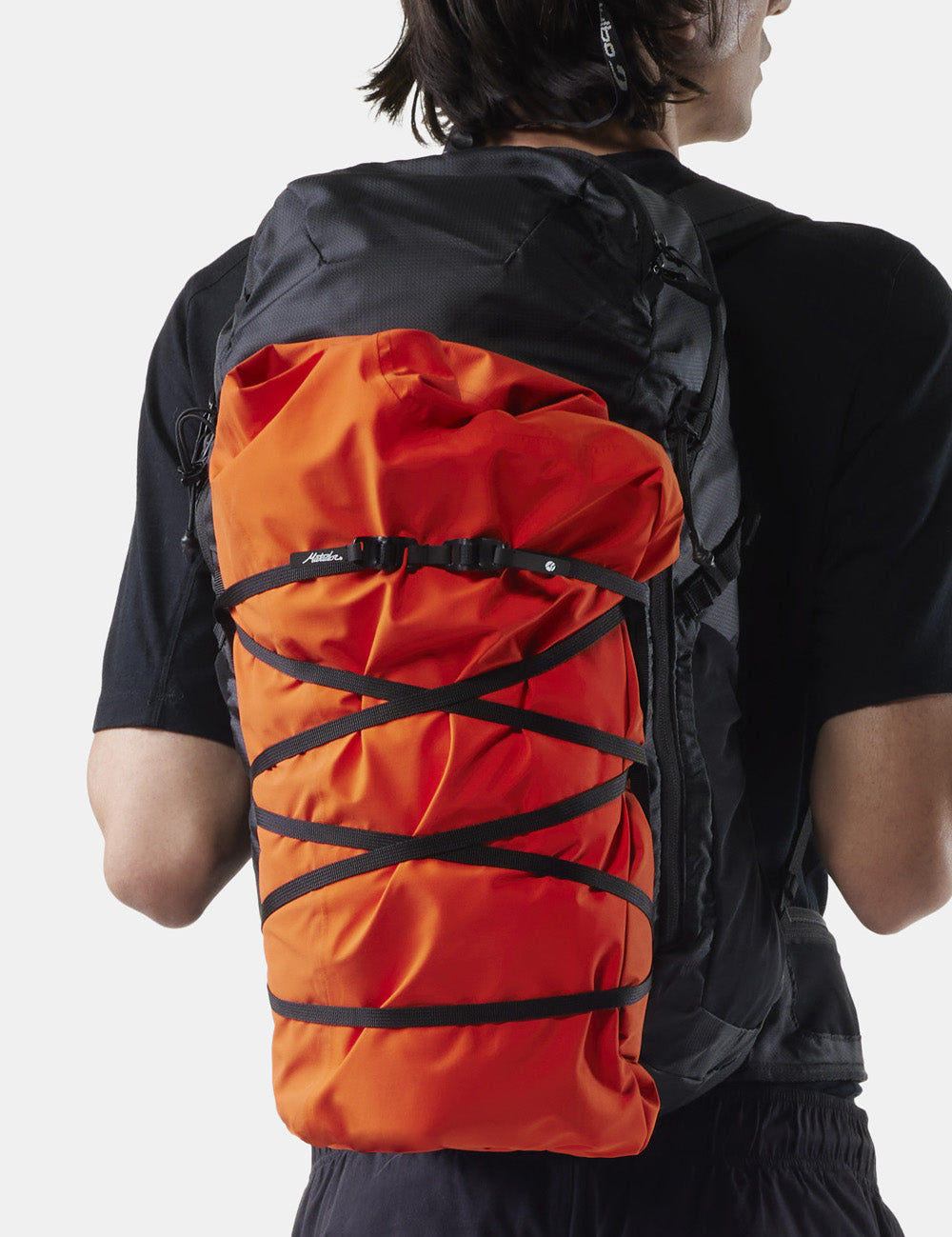 orange raincoat attached to person&#39;s backpack with better tether