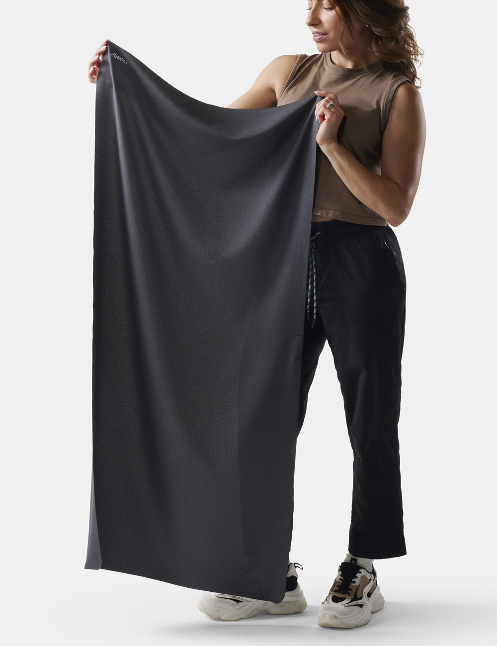 woman on white background holding up charcoal towel