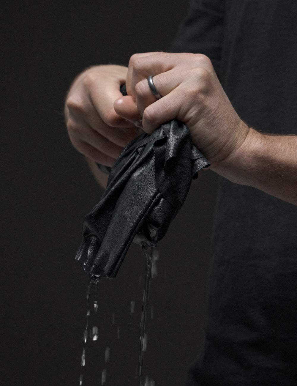 hands wringing out water from small towel