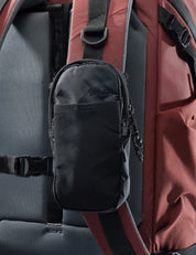 Black pouch attached to a red and gray backpack