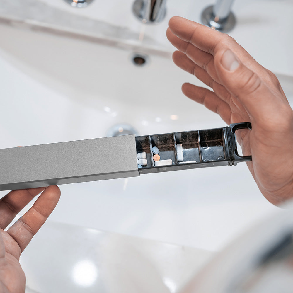 hands closing pill canister over bathroom sink