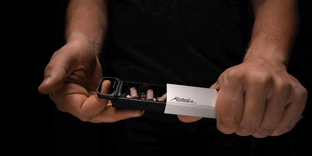 Hands opening pill canister on dark background