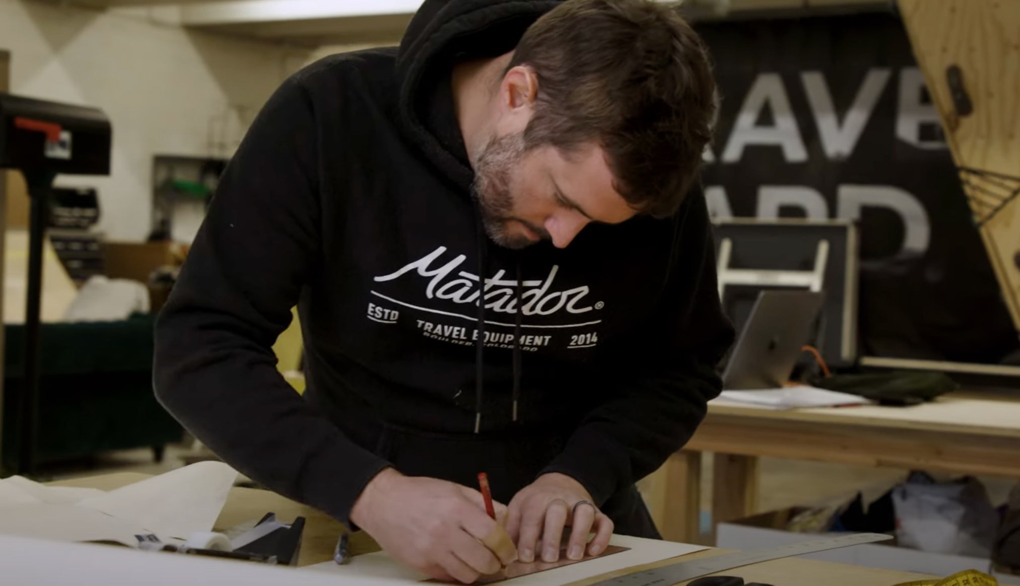 Man with Matador sweatshirt, cutting fabric