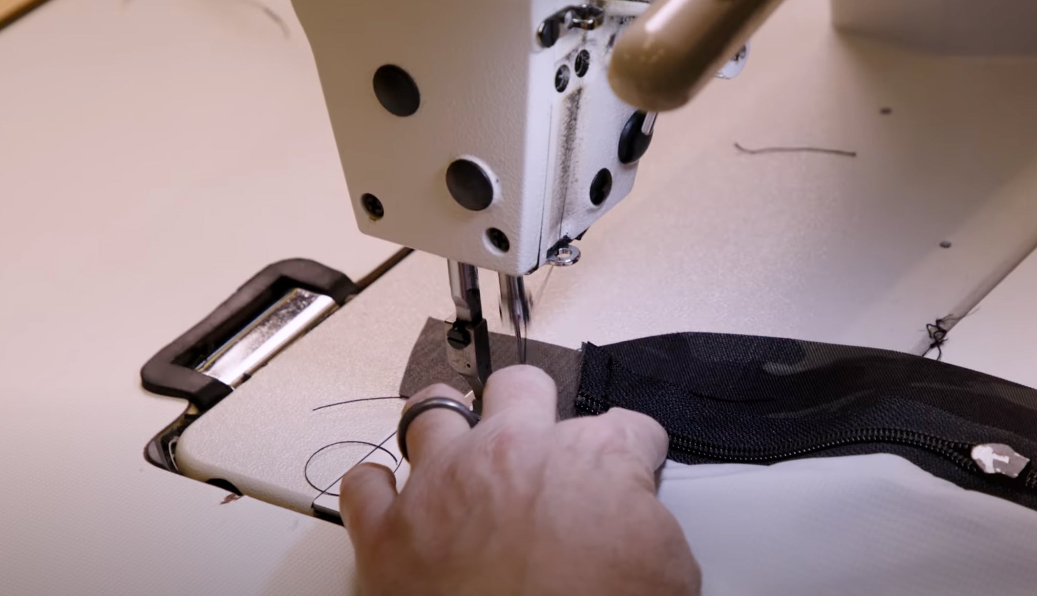 Hands placing zipper in sewing machine