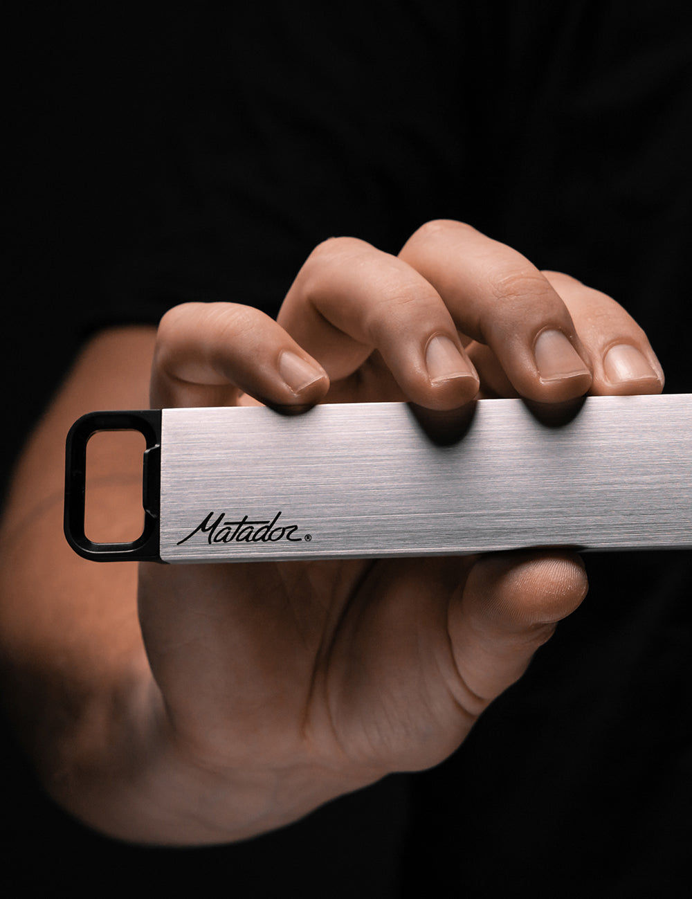 hand in dark studio, holding pill canister