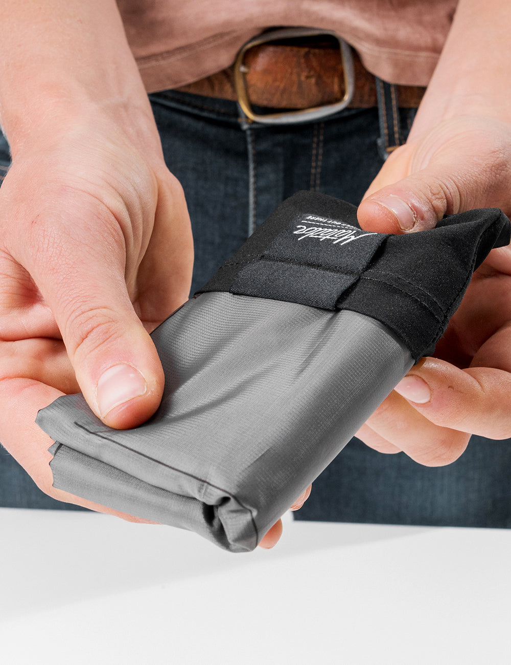 hands pulling pocket blanket from storage bag