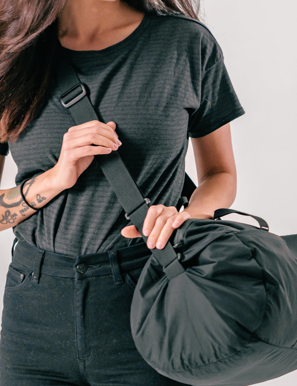 woman wearing black duffle across her body