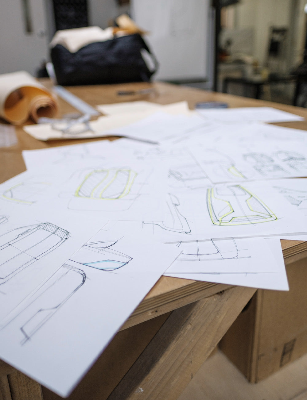 Pile of backpack drawings scattered about a work bench