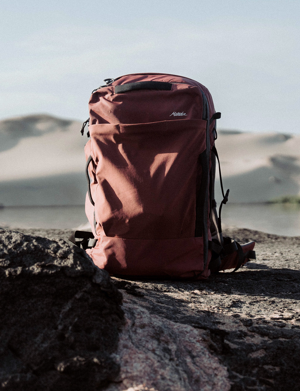 Garnet Globerider35 sitting on rocky surface in front of desert scene